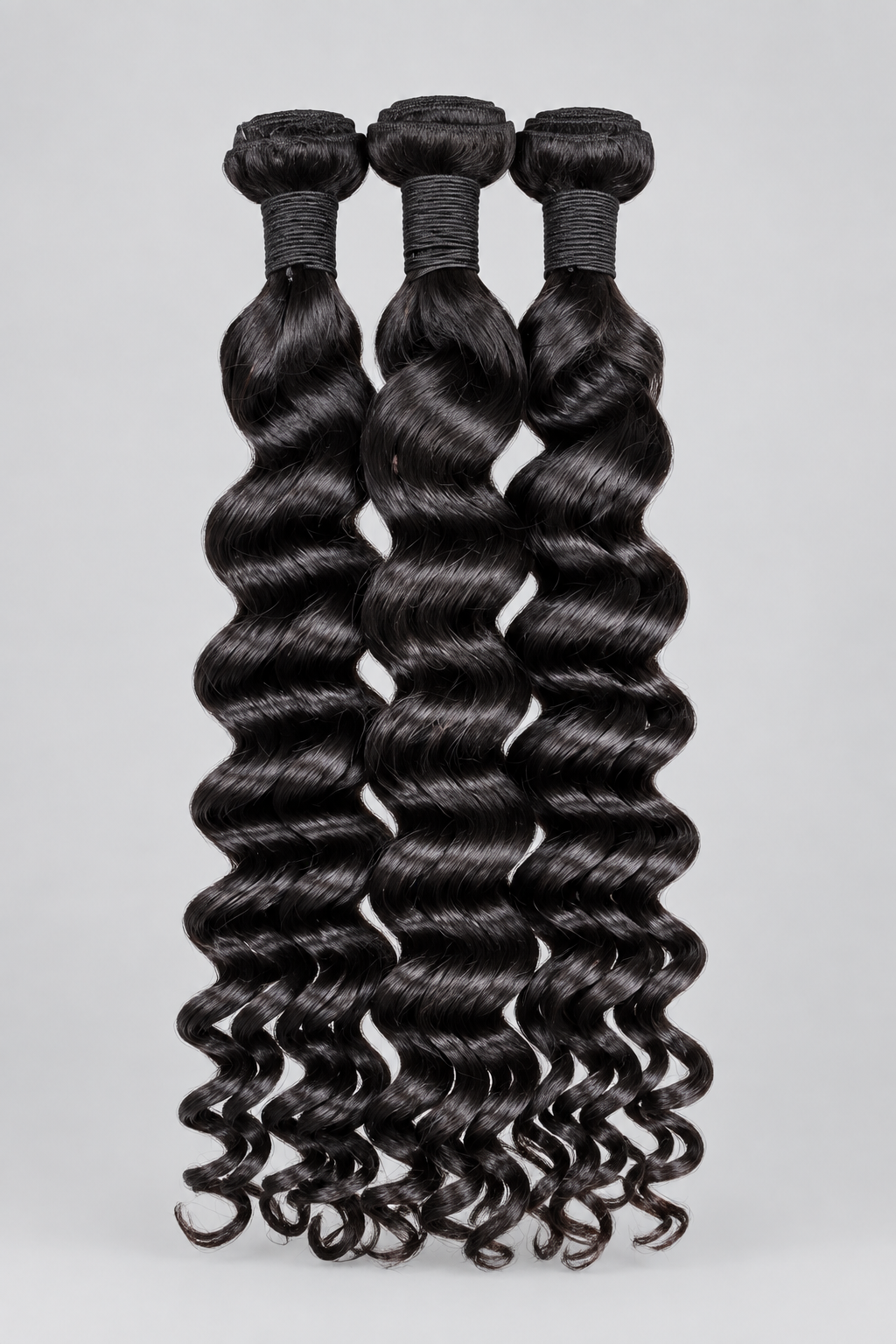 Three bundles of dark brown to black deep wave hair extensions held up by hands, with a white text overlay reading 'EXOTIC WAVE' across the center. The background features green house plants, a desk, and a map on a wall.